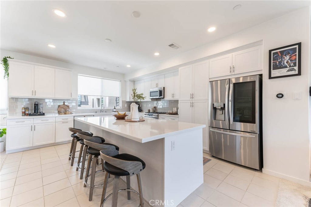 13161 Victory Boulevard Valley Glen, CA 91401 - Photo 10 of 33 a kitchen with stainless steel appliances kitchen island a table and chairs in it