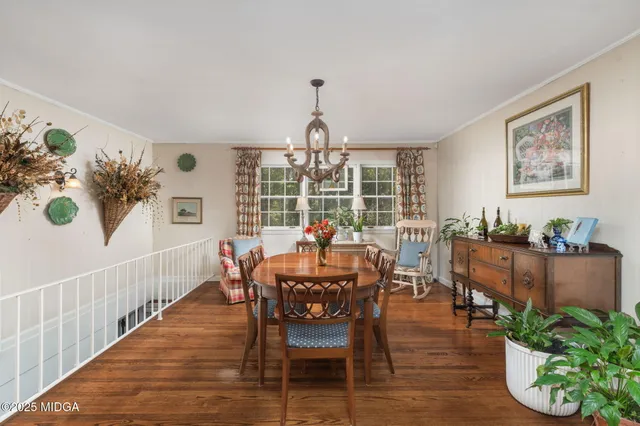 a dining room with furniture potted plants and wooden floor