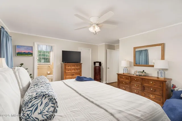 a bedroom with a large bed and a flat tv screen on dresser