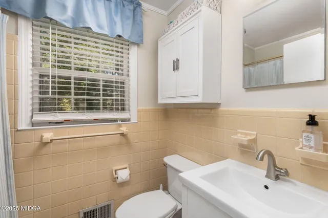 a bathroom with a toilet sink and mirror