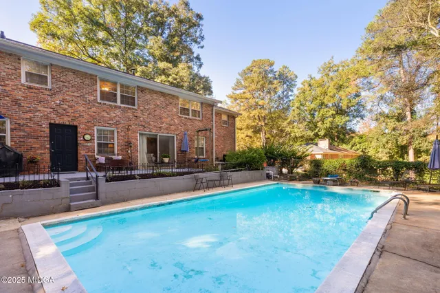 a view of a house with swimming pool and sitting area