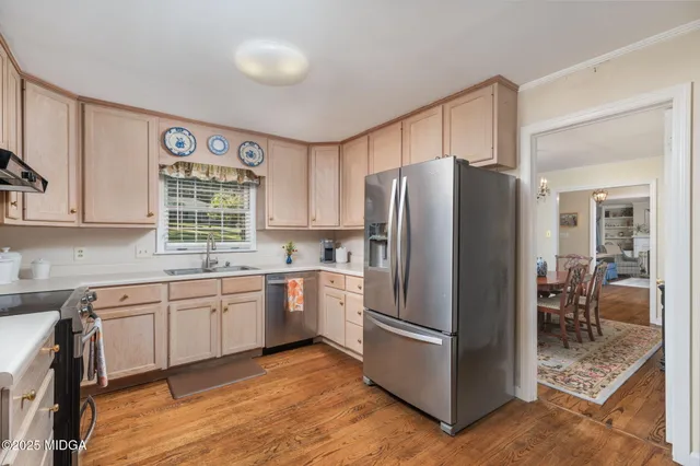 a kitchen with stainless steel appliances a refrigerator sink and cabinets