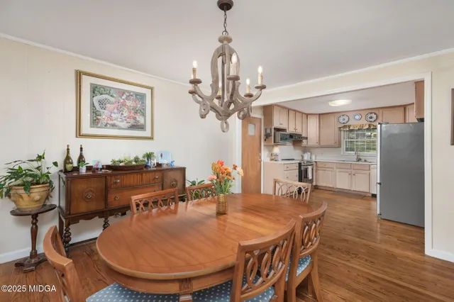 a dining room filled chandelier and wooden floor