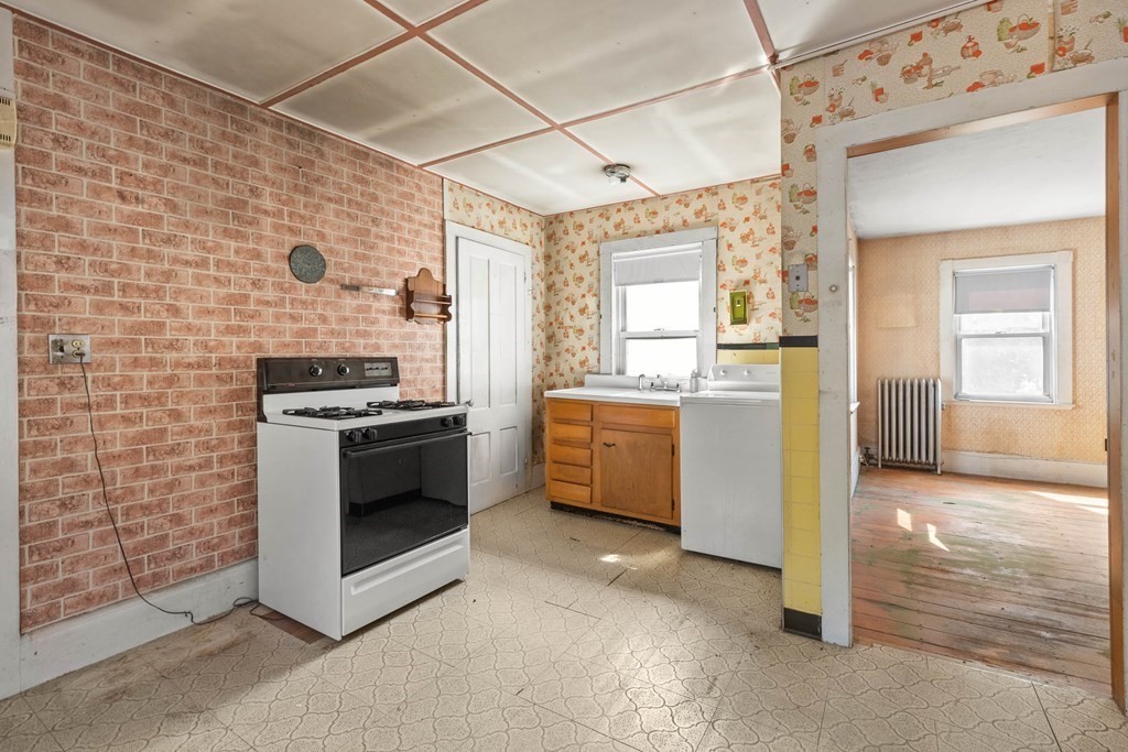 31 Andover Street Peabody, MA 01960 - Photo 24 of 40 a kitchen with a stove a sink and a refrigerator