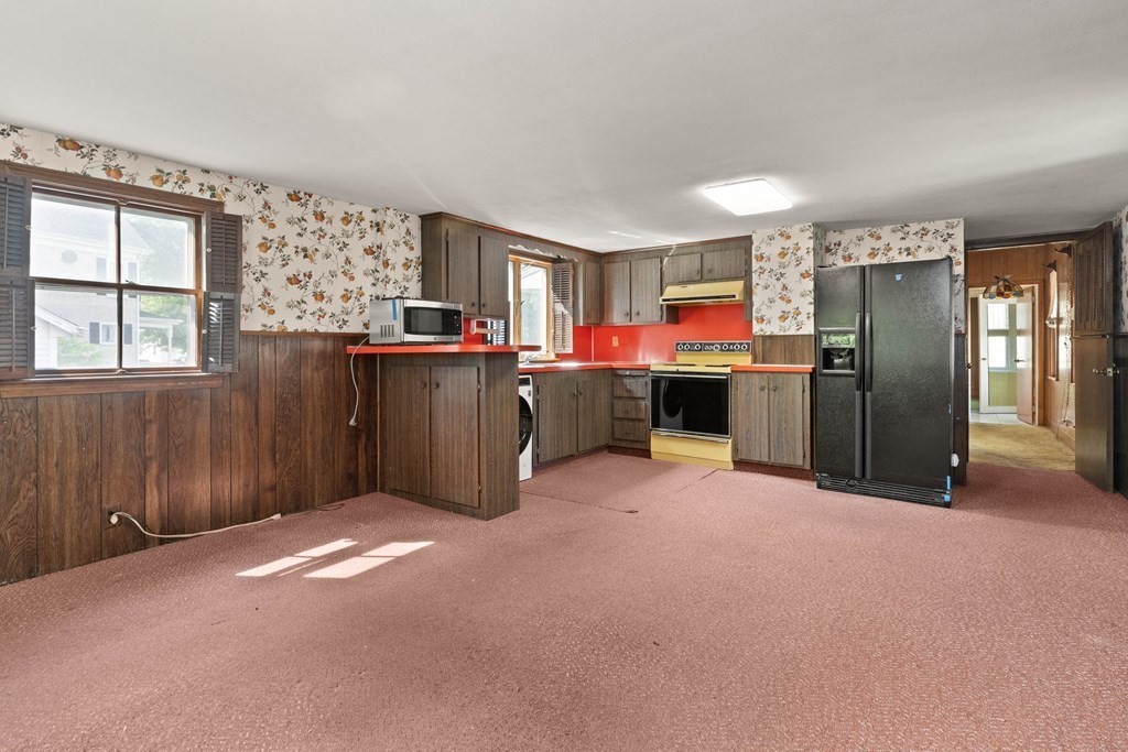 31 Andover Street Peabody, MA 01960 - Photo 6 of 40 a view of a kitchen with a refrigerator a stove top oven and a refrigerator
