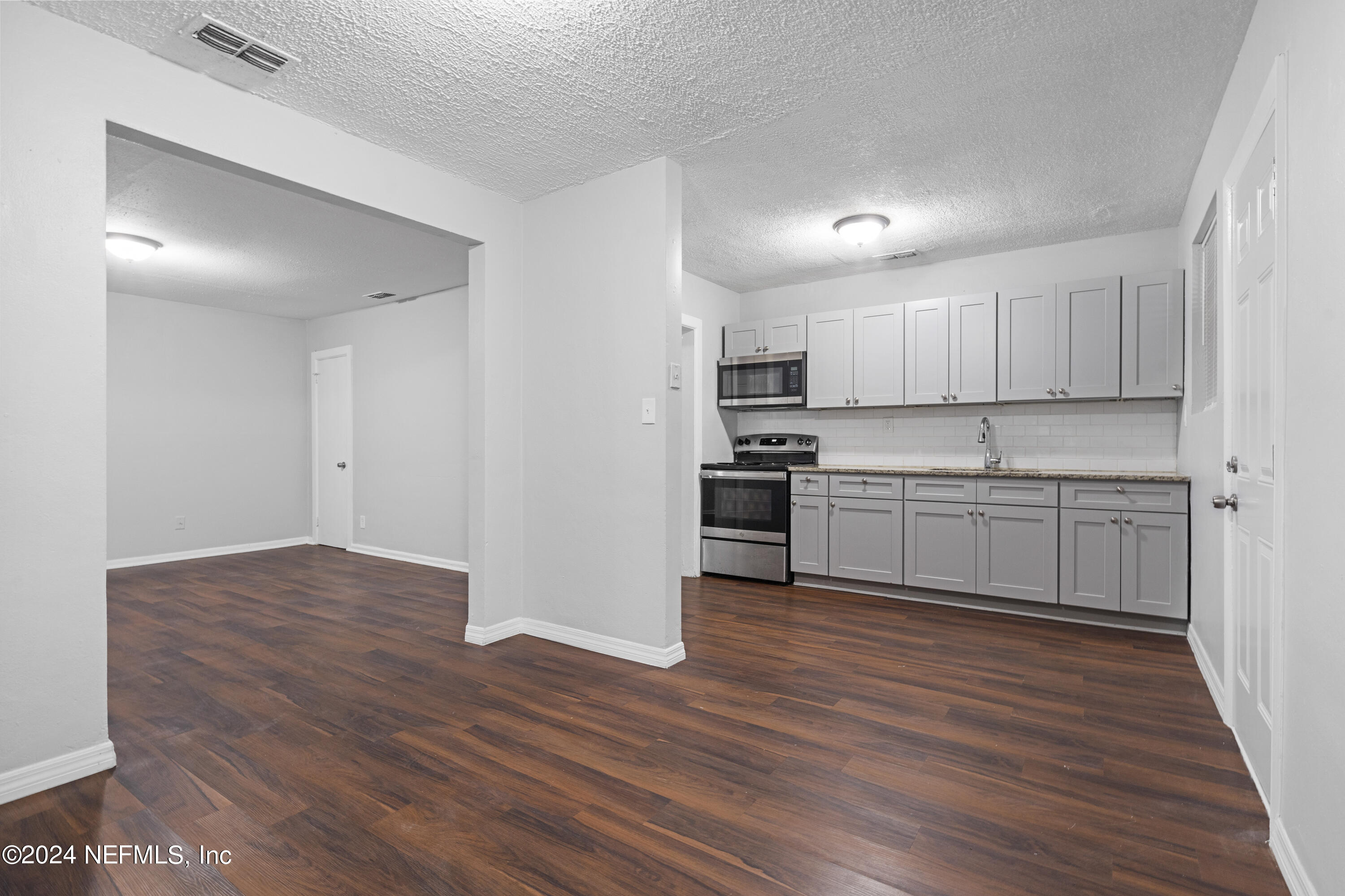 1174 Mohawk Street Jacksonville, FL 32205 - Photo 14 of 33 a kitchen with wooden floors and white appliances