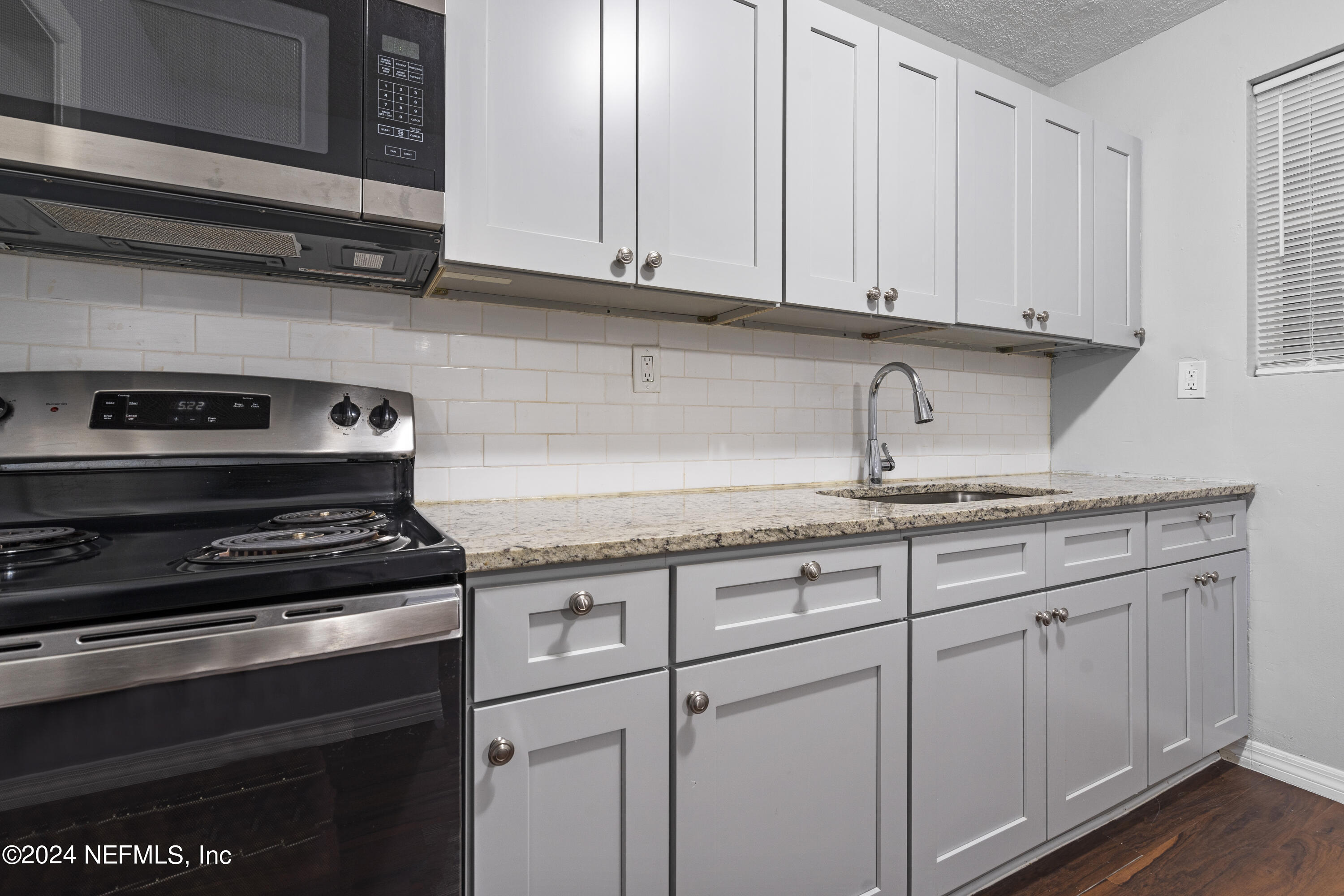 1174 Mohawk Street Jacksonville, FL 32205 - Photo 17 of 33 a kitchen with granite countertop white cabinets and a stove