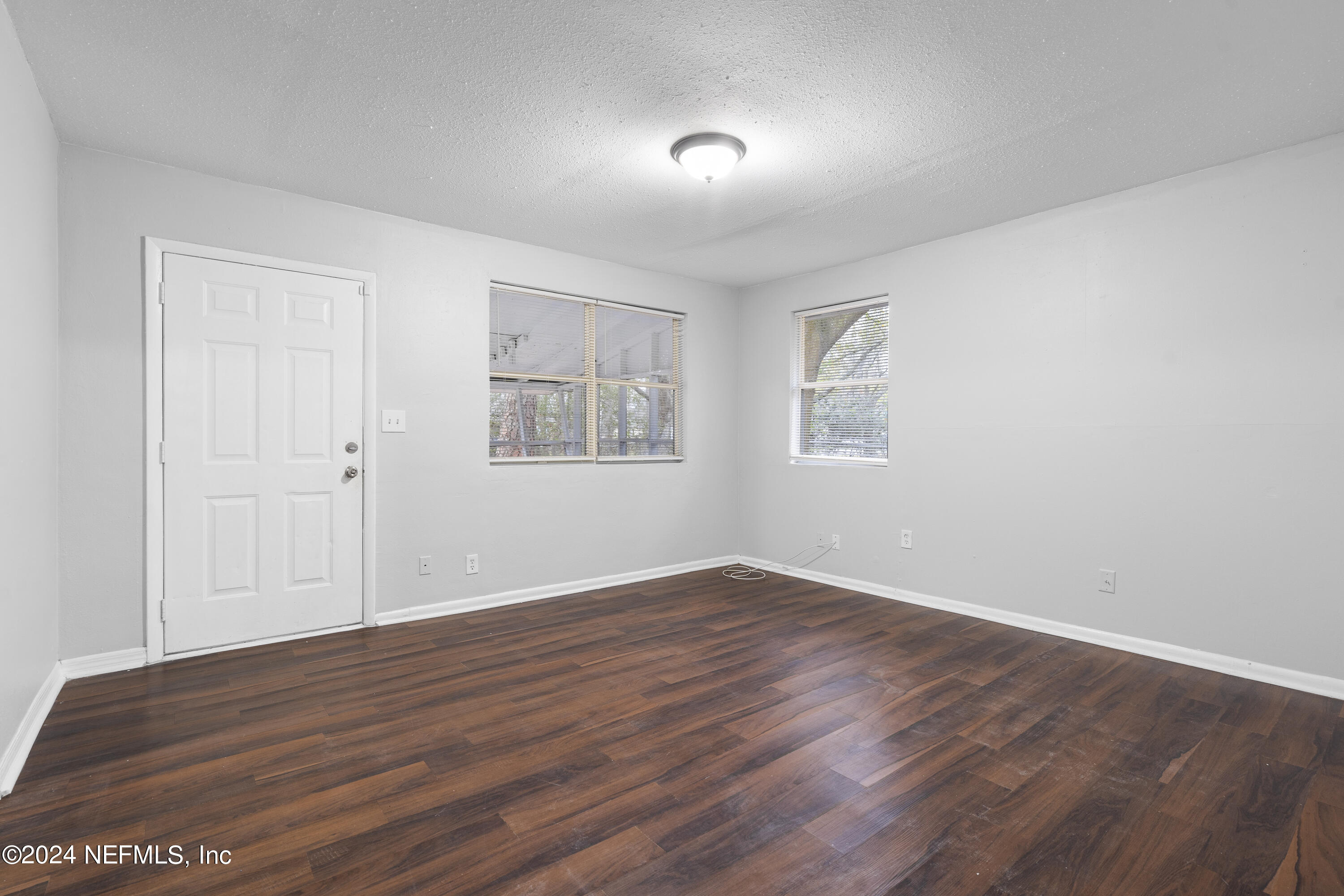 1174 Mohawk Street Jacksonville, FL 32205 - Photo 9 of 33 an empty room with wooden floor and windows