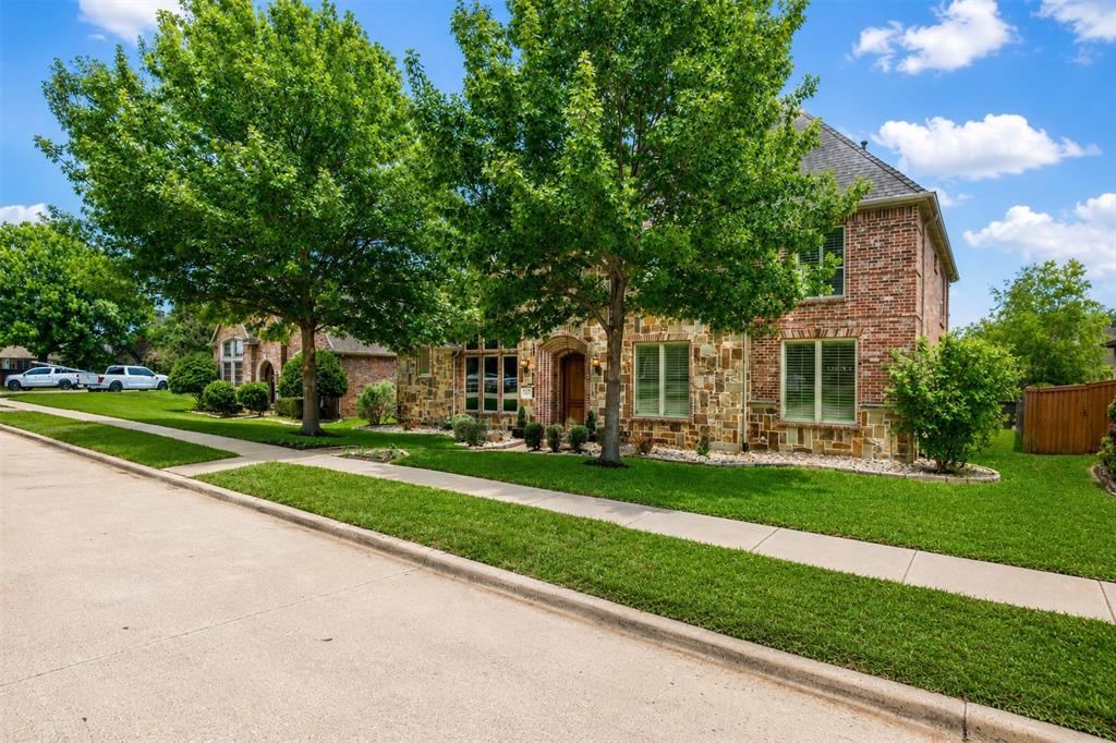 967 East Bethel School Road Coppell, TX 75019 - Photo 5 of 39 Exterior facade featuring a combination of brick and stone, mature trees, manicured lawn, concrete sidewalk, and a paved street
