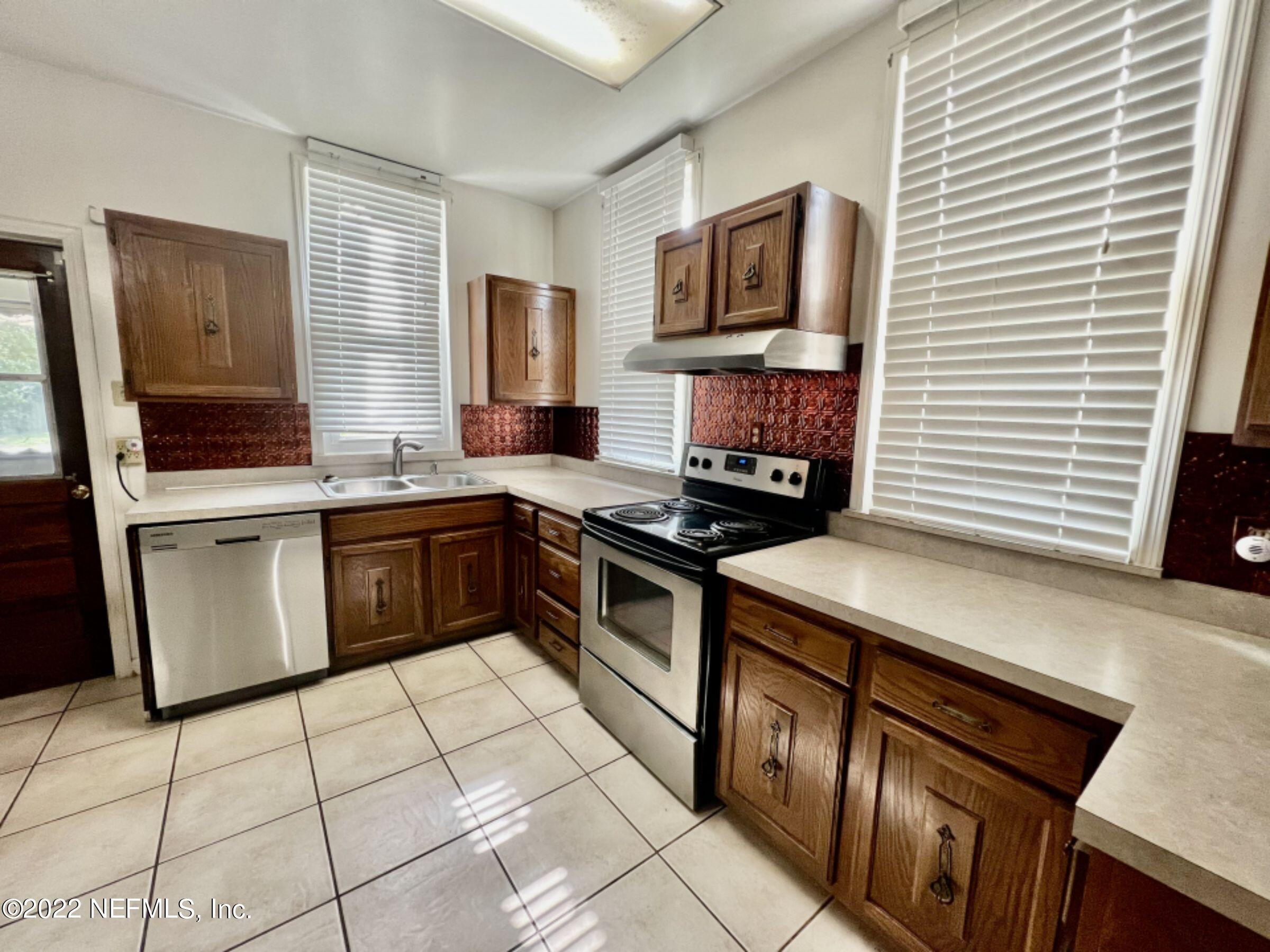 7044 Wheat Road Jacksonville, FL 32244 - Photo 27 of 32 a kitchen with stainless steel appliances a stove sink microwave and cabinets