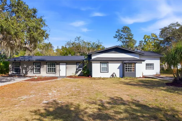 a front view of a house with a yard and trees