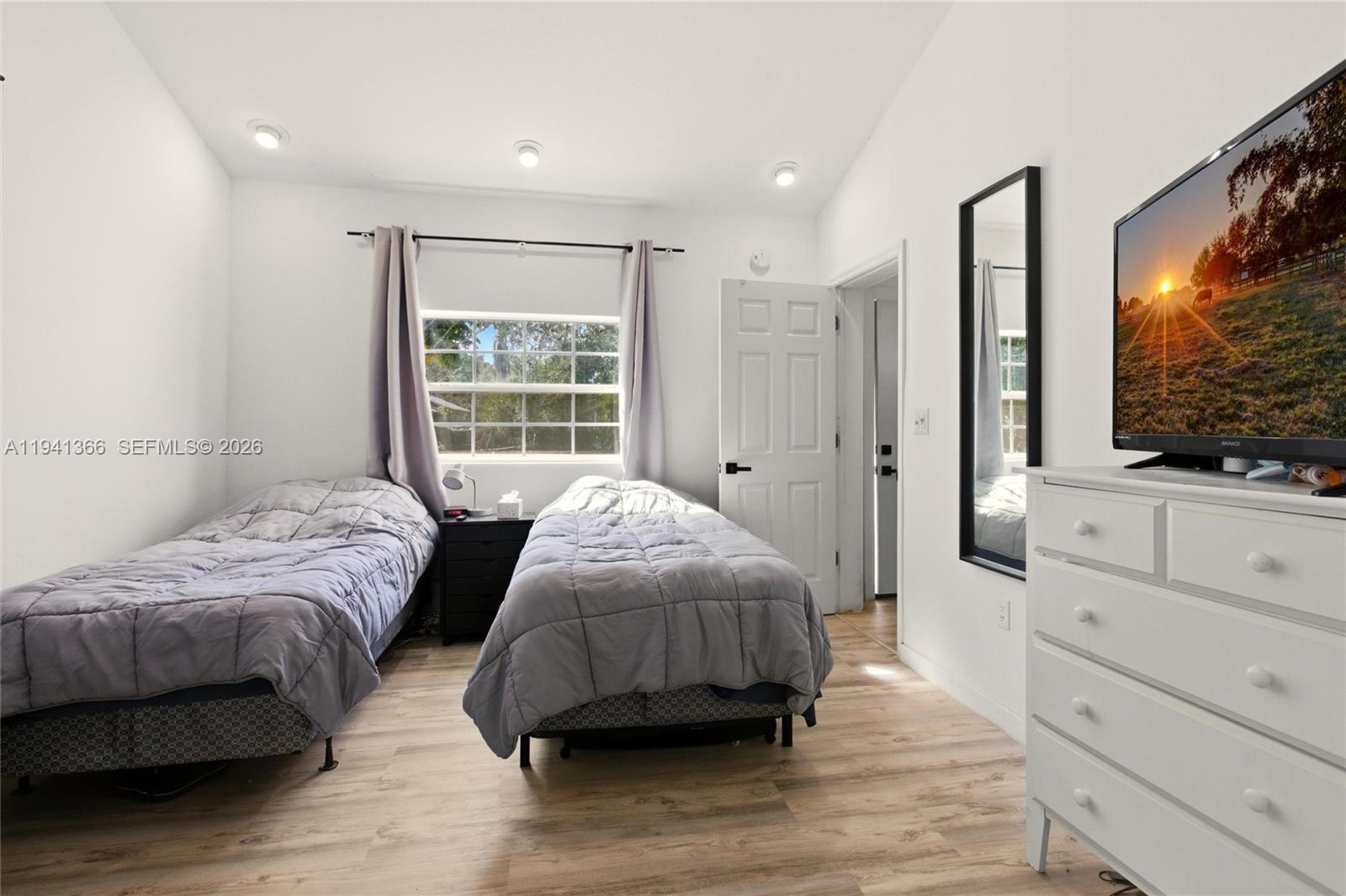 2124 Gardenview Road Sebring, FL 33870 - Photo 38 of 54 a bedroom with a large bed and a flat tv screen on dresser