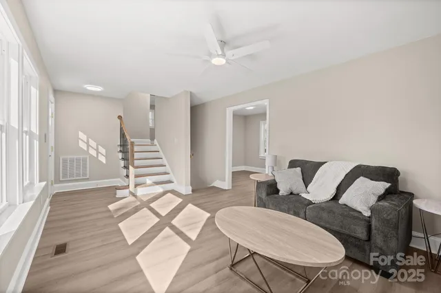 a living room with furniture and a wooden floor