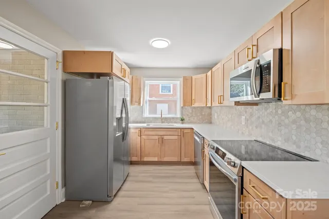 a kitchen with a refrigerator sink and cabinets