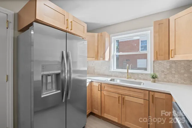 a kitchen with a refrigerator a sink and cabinets