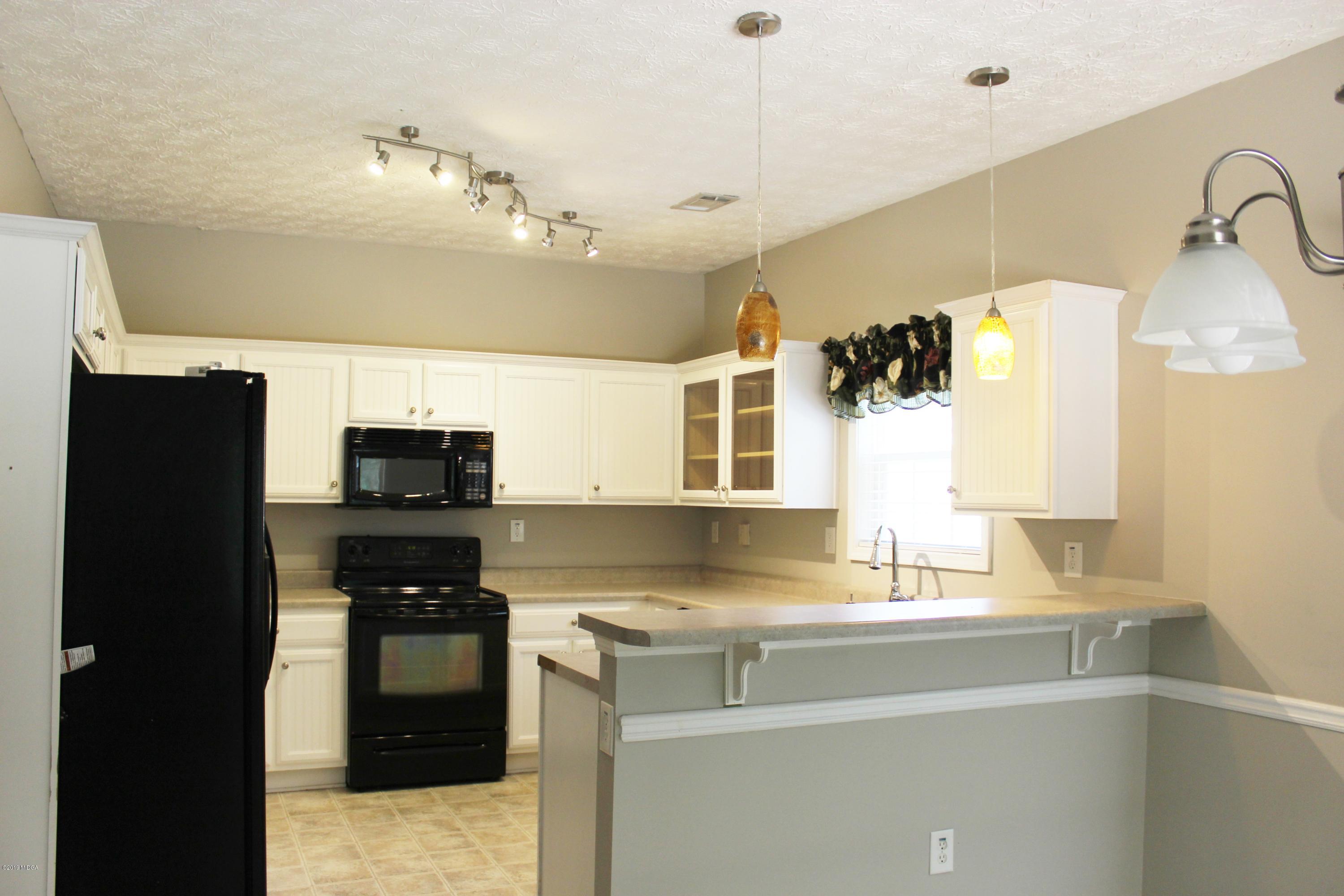 318 Hickory Road Jackson, GA 30233 - Photo 4 of 13 a kitchen with stainless steel appliances granite countertop a sink and a refrigerator