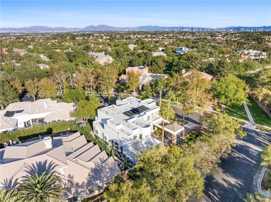 2000 Grouse Street Las Vegas, NV 89134 - Photo 80 of 89 An aerial perspective reveals a modern architectural residence nestled among mature trees within a sprawling suburban landscape.