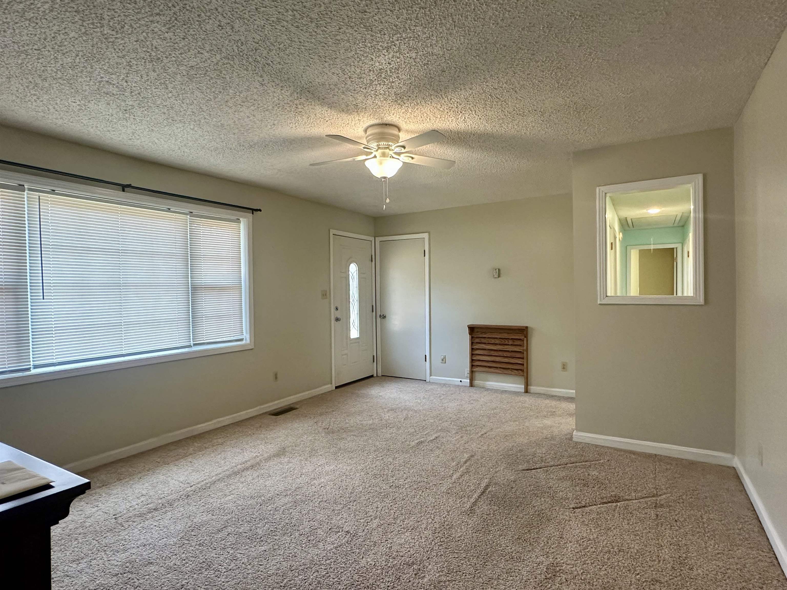 an empty room with windows and fan