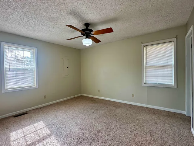 an empty room with a window and a fan
