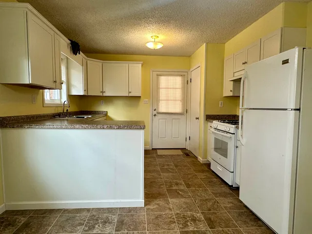 a kitchen with stainless steel appliances a refrigerator sink and cabinets
