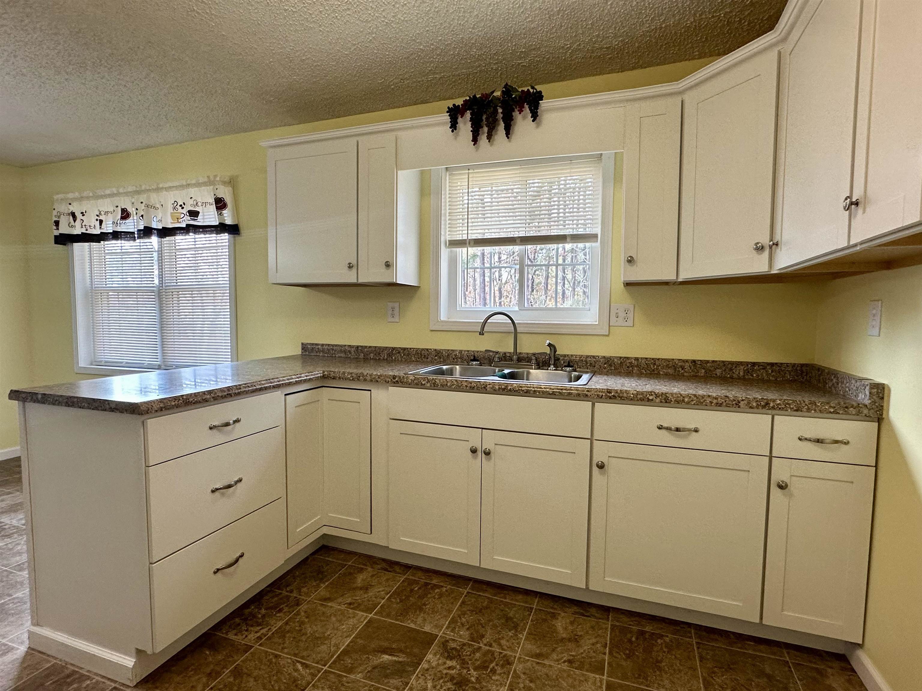 170 Mitchell Street Selmer, TN 38375 - Photo 5 of 26 a kitchen with granite countertop white cabinets and white appliances