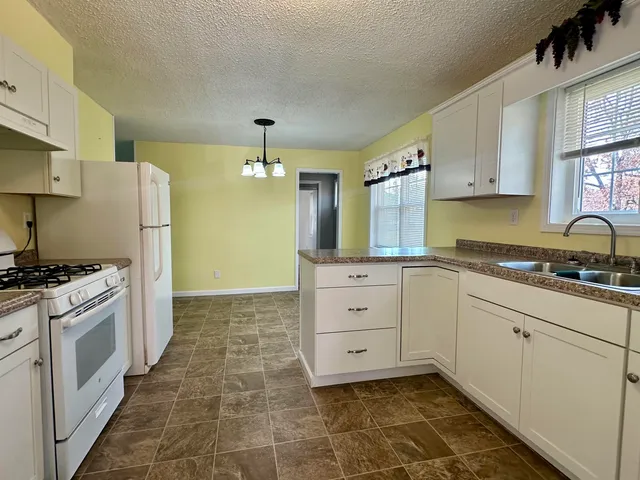a kitchen with white cabinets and appliances