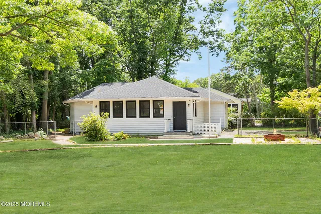 a front view of a house with a yard patio and trees