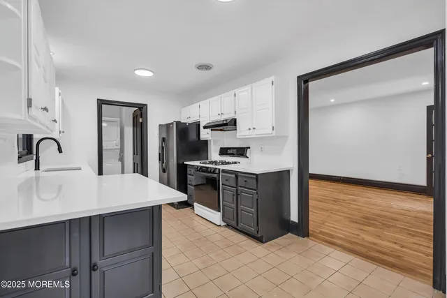 a kitchen with kitchen island white cabinets and refrigerator