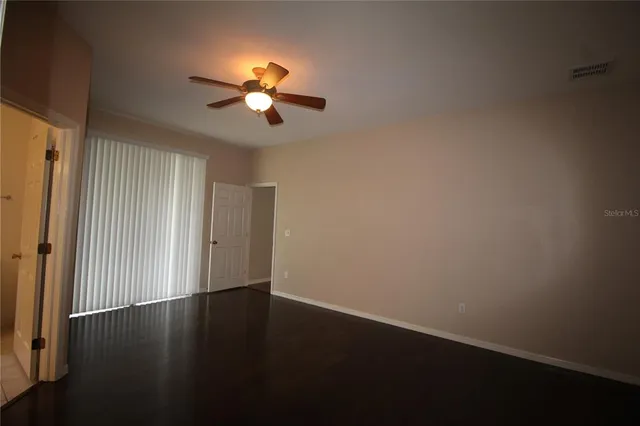 a view of a room with wooden floor and chandelier fan