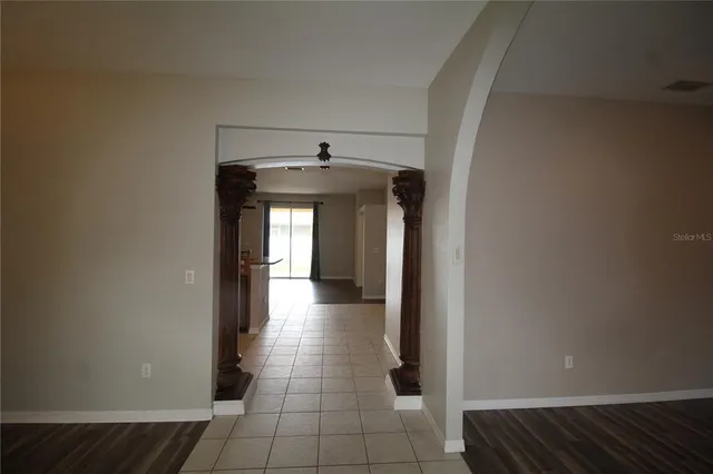a view of a hallway with wooden floor and chandelier