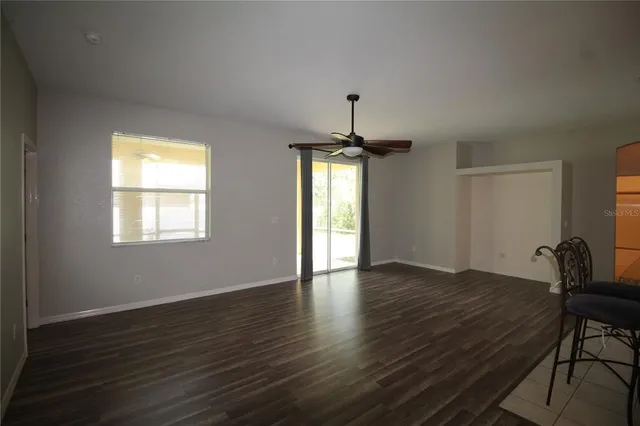 a view of an empty room with window and wooden floor