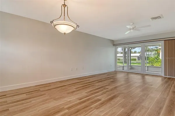 a dining room with furniture a large window and potted plants