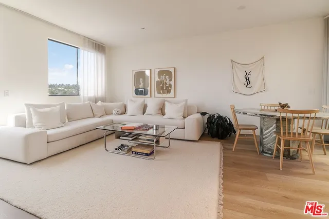 a living room with furniture wooden floor and dining table