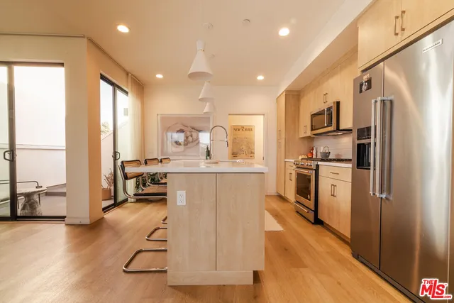 a kitchen with stainless steel appliances granite countertop a refrigerator and a stove top oven