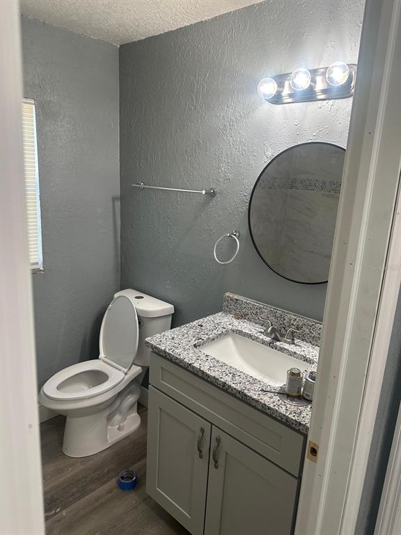 724 Grove Avenue Orlando, FL 32805 - Photo 4 of 6 a bathroom with a granite countertop toilet sink and mirror