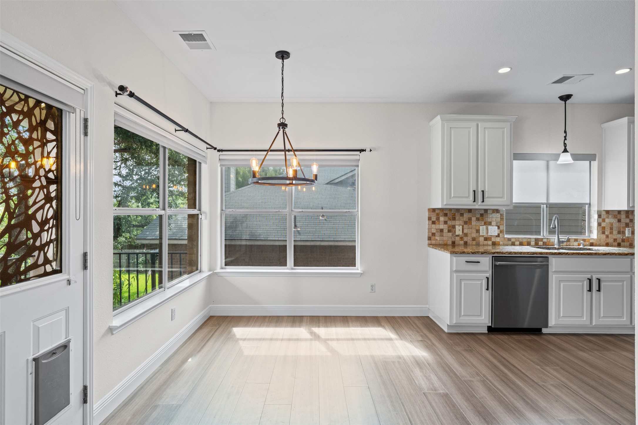8820 Colberg Drive Austin, TX 78749 - Photo 9 of 35 Luminous dining area with sleek flooring, bathed in natural light and anchored by a stylish chandelier.