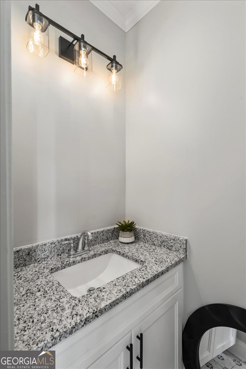 323 South Madison Avenue Monroe, GA 30655 - Photo 16 of 39 a bathroom with a granite countertop sink and a mirror