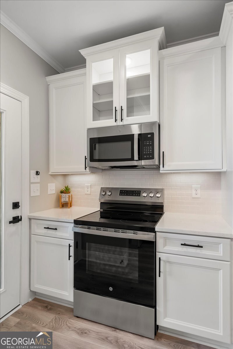 323 South Madison Avenue Monroe, GA 30655 - Photo 20 of 39 a kitchen with stainless steel appliances white cabinets and a stove