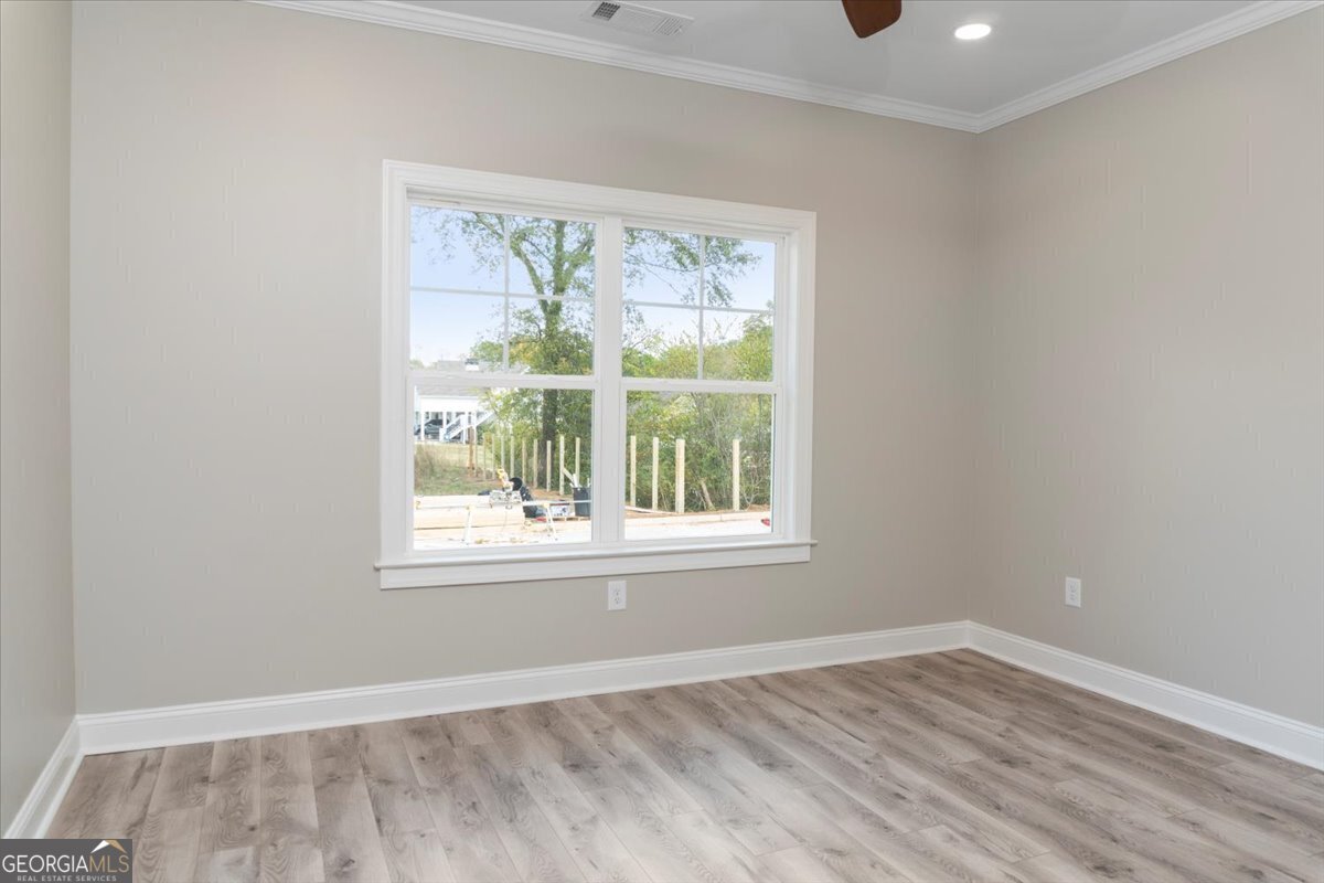 323 South Madison Avenue Monroe, GA 30655 - Photo 22 of 39 an empty room with wooden floor and a window