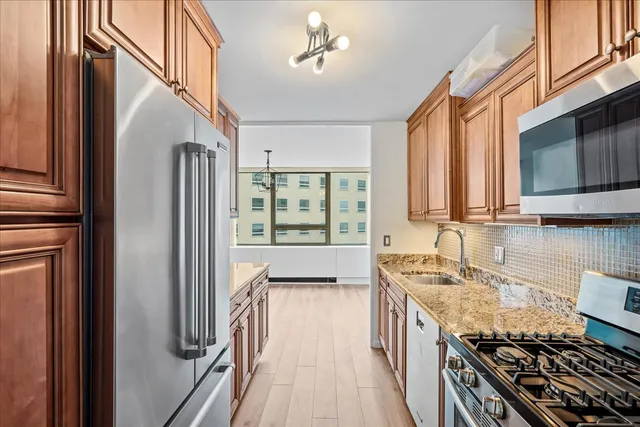 a kitchen with stainless steel appliances granite countertop a sink stove and refrigerator