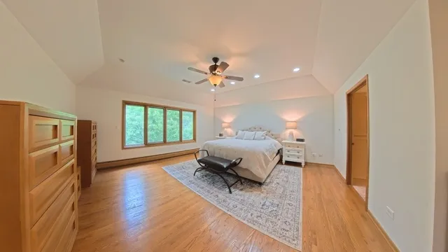 a spacious bedroom with a bed and a chandelier