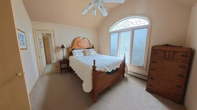 a spacious bedroom with a bed and a chandelier