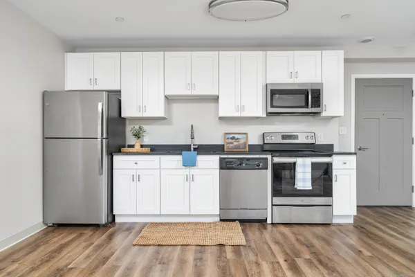 a kitchen with white cabinets and stainless steel appliances