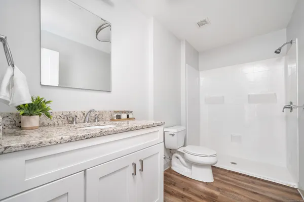 a bathroom with a granite countertop sink a toilet and a mirror