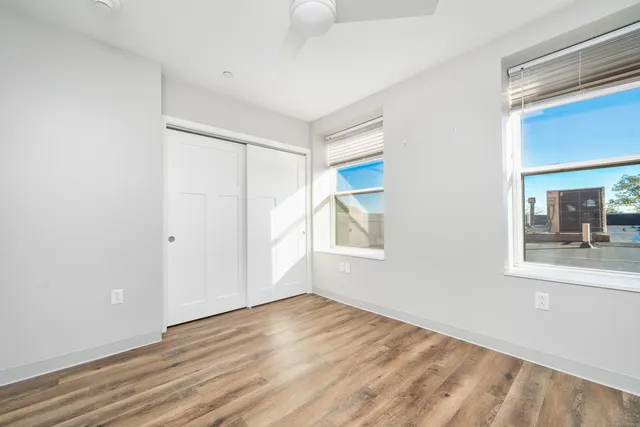 an empty room with wooden floor and windows