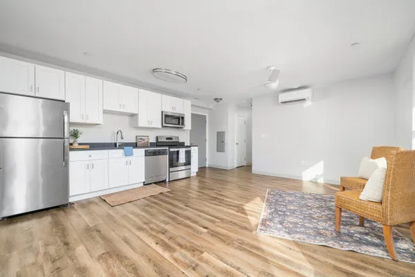 a kitchen with stainless steel appliances granite countertop a refrigerator sink and white cabinets