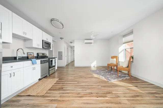 a kitchen with granite countertop a stove and white cabinets