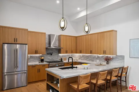 a kitchen with stainless steel appliances granite countertop a sink refrigerator and cabinets