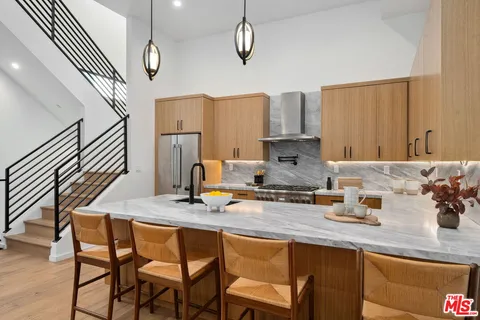 a kitchen with stainless steel appliances granite countertop a sink a stove and a wooden floors