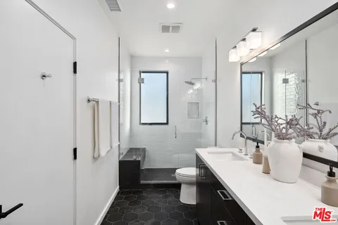 a bathroom with a double vanity sink and mirror